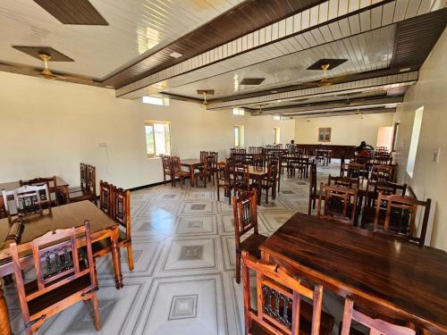 een leeg restaurant met houten tafels en stoelen bij Hotel Patel Heritage Sam in Sām