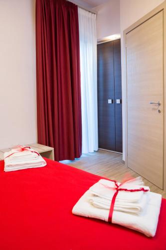 a red bed with two white towels on top of it at SONRE' B&B in Ruffano