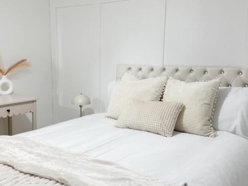 a white bed with white sheets and pillows at Modern 3BR House Near Bolton & Manchester in Farnworth