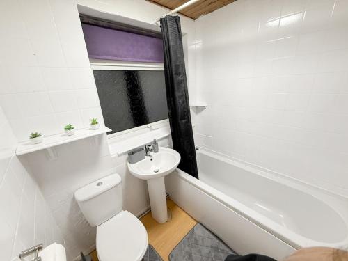 a bathroom with a toilet and a sink and a bath tub at Modern 3BR House Near Bolton & Manchester in Farnworth