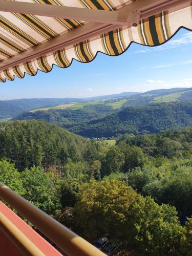 una vista dal balcone di una casa con vista sugli alberi di Ferienwohnung Sonnenschein mit Pool und Sauna a Lahnstein