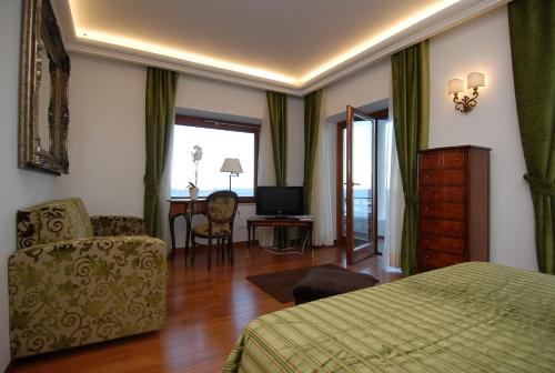 a bedroom with a bed and a chair and a television at Diva La Canzone Del Mare in Capri