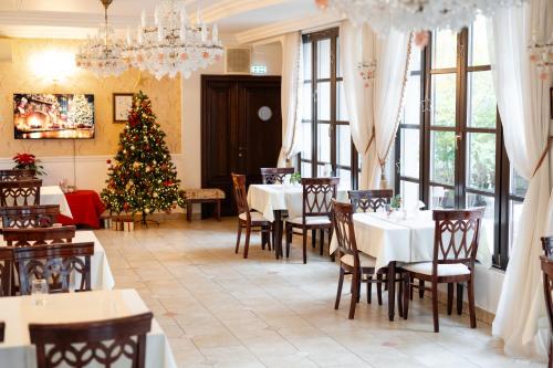 a restaurant with a christmas tree and tables and chairs at Hotel Royal Plaza By TimHotels in Timişoara