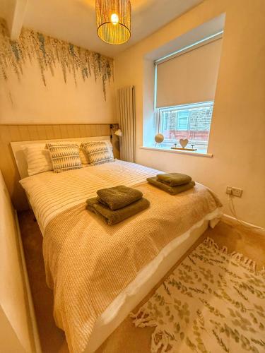 a bedroom with a bed with two towels on it at Orchard Nook Cottage, 1 bedroom in Barnoldswick