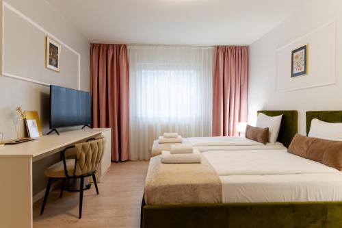a hotel room with two beds and a desk at Hotel Royal Plaza By TimHotels in Timişoara