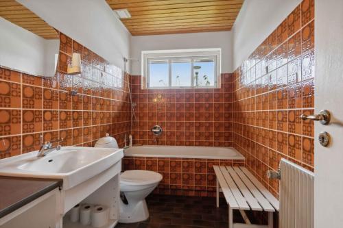 een badkamer met een wastafel, een toilet en een bad bij Cozy Holiday Home In Thisted in Thisted