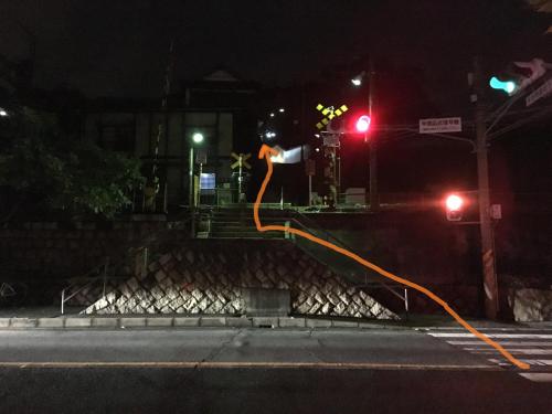 a traffic light with a person in the air at night at Onomichi Guest House Miharashi-tei in Onomichi