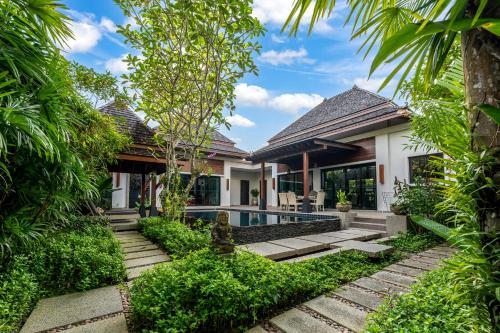 a home with a swimming pool and trees at The Bell Pool Villa Resort Phuket in Kamala Beach