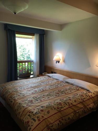 a bedroom with a large bed with a window at Garni Enrosadira in Vigo di Fassa