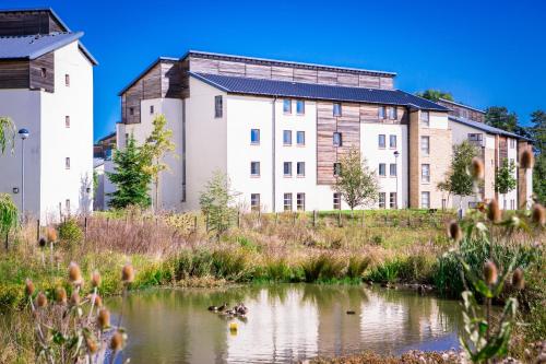 an apartment building in front of a pond at David Russell Hall - Campus Accommodation in St. Andrews