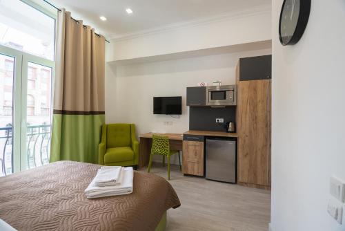a room with a bed and a kitchen with a microwave at Partner Guest House Khreschatyk in Kyiv