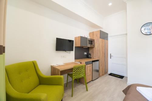 a living room with a green chair and a desk at Partner Guest House Khreschatyk in Kyiv