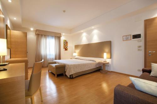 Habitación de hotel con cama y sofá en Hotel Campiello, en San Giovanni al Natisone