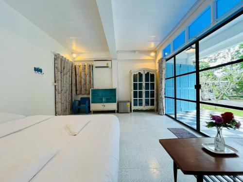 een slaapkamer met een groot wit bed en een tafel bij Today Sunset ที่พักวังน้ำเขียว in Ban Nong Chaeng