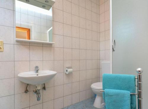 een badkamer met een wastafel, een toilet en een spiegel bij Sobe Melada in Trilj