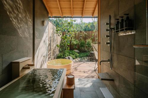 ein Badezimmer mit Badewanne und Waschbecken in der Unterkunft Kasan in Kirishima