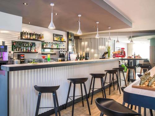 eine Bar in einem Restaurant mit Hockern in der Unterkunft Novotel Nice Centre Vieux Nice in Nizza