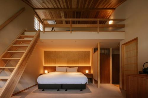 ein Schlafzimmer mit einem Bett und einer Treppe in der Unterkunft Kasan in Kirishima
