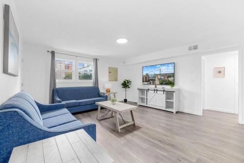 a living room with a blue couch and a table at Azul Condos - Ocean steps away - Full Kitchen in Myrtle Beach