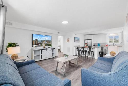 a living room with two blue couches and a kitchen at Azul Condos - Ocean steps away - Full Kitchen in Myrtle Beach