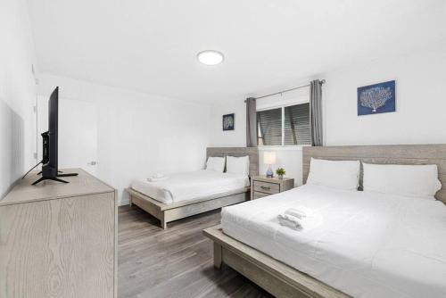 a bedroom with two beds and a flat screen tv at Azul Condos - Ocean steps away - Full Kitchen in Myrtle Beach