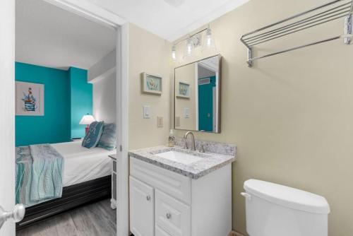 a bathroom with a sink and a toilet and a bed at Oceanfront 1BR Condo with Corner Balcony Pool in Myrtle Beach