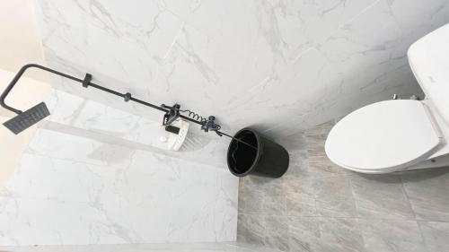 bagno bianco con servizi igienici e parete in marmo bianco di Teem Living Jogja a Jejeran