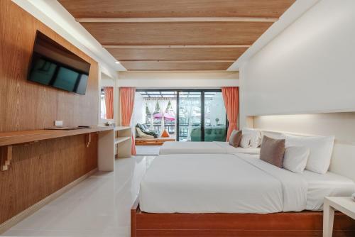 a bedroom with two beds and a tv at Phuvaree Resort in Patong Beach