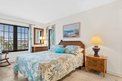 een slaapkamer met een bed, een lamp en een raam bij Sea Marsh II Stunning Beachfront Stay in Myrtle Beach