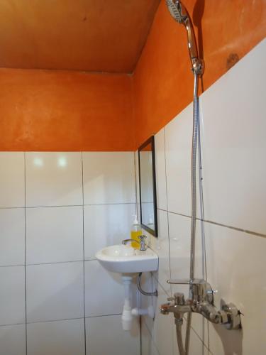 een badkamer met een wastafel en een douche bij meta bungalow in Senaru