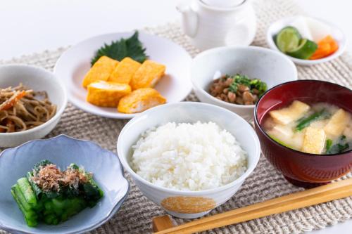een tafel met kommen rijst en ander eten bij Fuji Matsuzono Hotel in Yamanakako