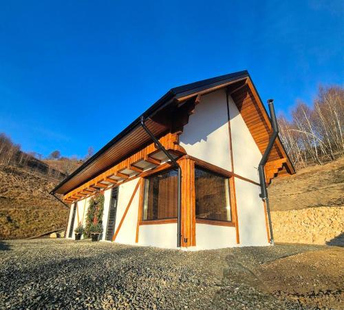 een klein huis met een groot raam aan de zijkant bij The White House in Şirnea