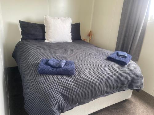 En eller flere senge i et værelse på Cute little Foxton Beach bach