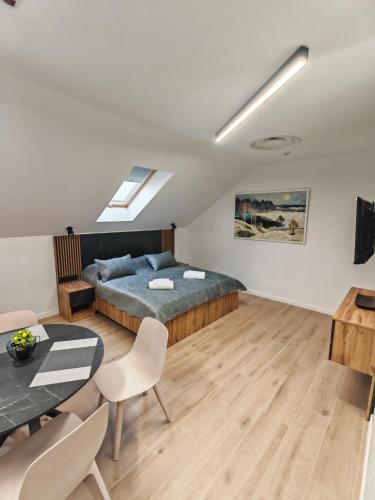 una camera da letto con un letto, un tavolo e delle sedie di 44roomsMarghita a Marghita