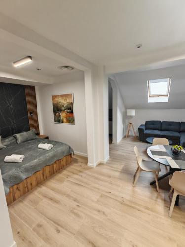 a bedroom with a bed and a table and a couch at 44roomsMarghita in Marghita
