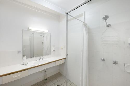 a white bathroom with a sink and a shower at Unit 133 Amaroo Standard Twin Studio Apartment in Nelly Bay
