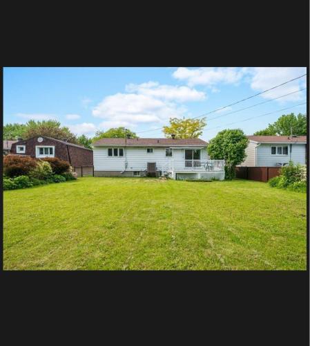 a large yard with a house and a house at Family-Friendly Private Room With 2 Queen Beds in Brossard