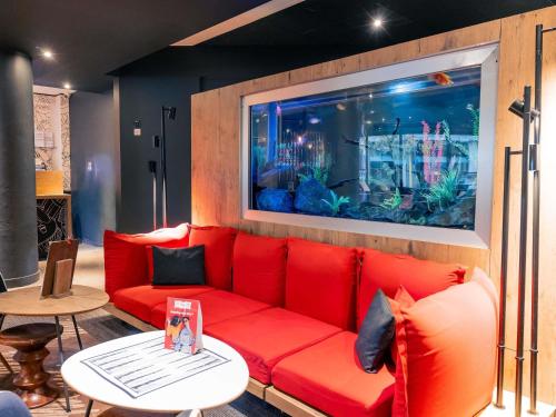 a living room with a red couch and an aquarium at ibis Portsmouth in Portsmouth