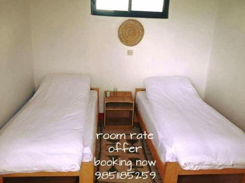 een kamer met twee bedden en een raam bij Hotel Gauri Inn Charikot in Dolakhā