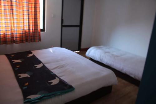 een slaapkamer met een bed waarop pandapillars zijn afgebeeld bij Hotel Gauri Inn Charikot in Dolakhā