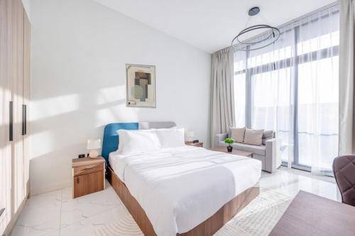 阿布扎比Bloomfields Iconic Studio at The Gate, Masdar City的白色卧室设有一张大床和一张蓝色椅子