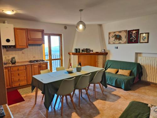 una cucina e un soggiorno con tavolo e sedie di Casa Viola della Maiella a Pennapiedimonte