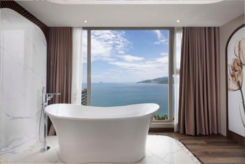 ein Badezimmer mit einer Badewanne vor einem großen Fenster in der Unterkunft Annova Nha Trang Hotel in Nha Trang