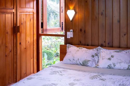 a bedroom with a bed with a window and a pillow at DuGiang Homestay in Buon Ma Thuot