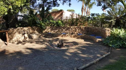 a stone wall in a yard with trees and plants at Mansfield Private Reserve in Port Alfred