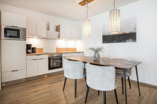 a kitchen with a wooden table and chairs at Ostseebrise Olpenitz in Olpenitz