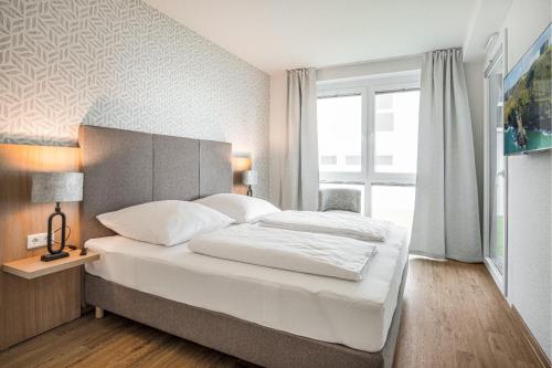 a bedroom with a bed and a large window at Ostseebrise Olpenitz in Olpenitz