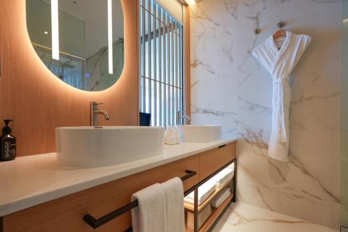 ein Badezimmer mit Waschbecken und Spiegel in der Unterkunft Homm Marina Sokcho in Sokcho