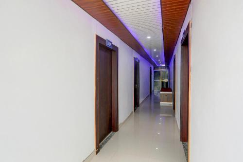 een gang van een ziekenhuis met houten deuren en witte muren bij HOTEL O MJ INN in Darbhanga