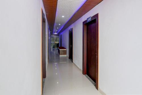 een gang met paarse muren en een deur in een gebouw bij HOTEL O MJ INN in Darbhanga